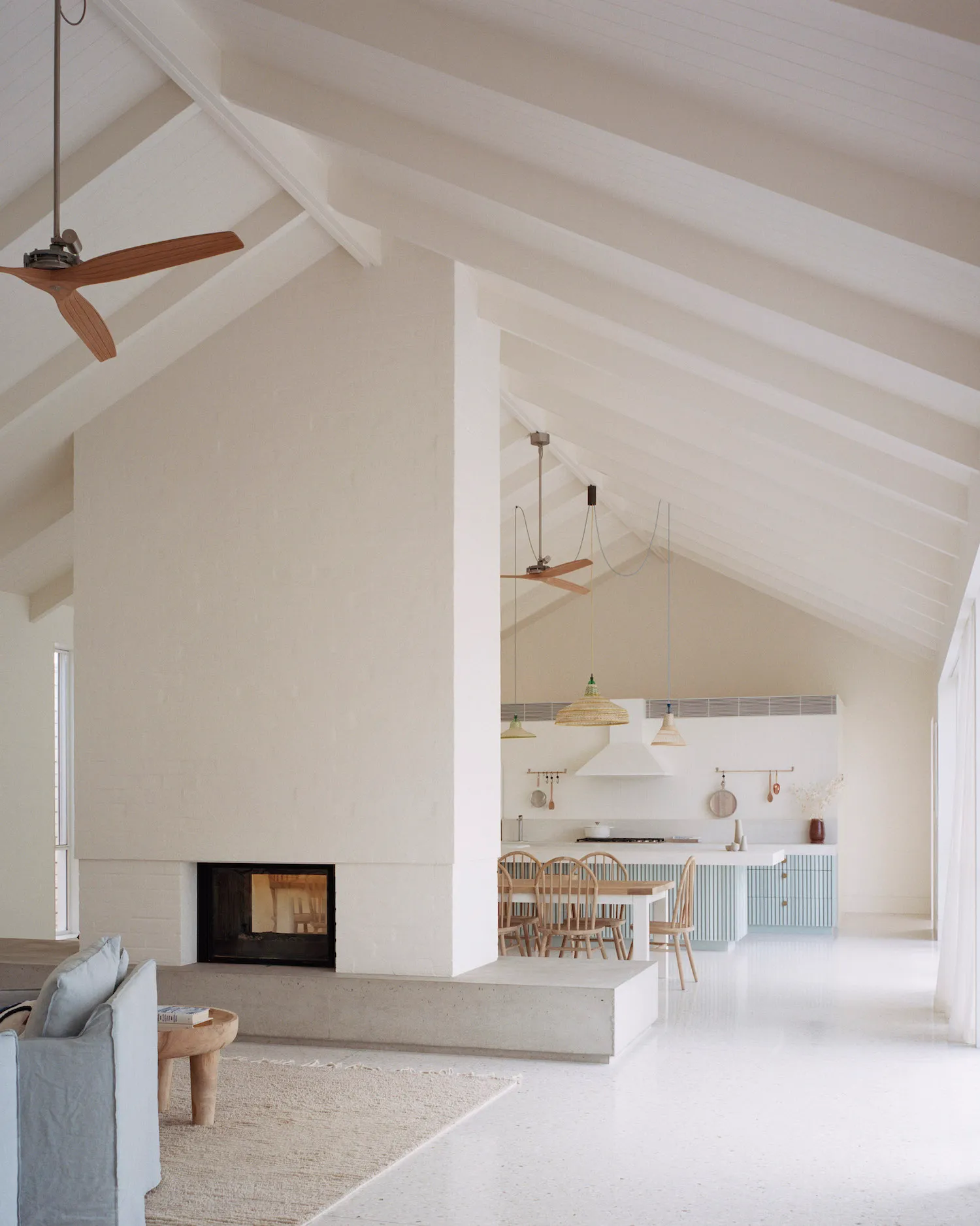 A white vaulted coastal living room with a pale terrazzo floor and a sunken lounge