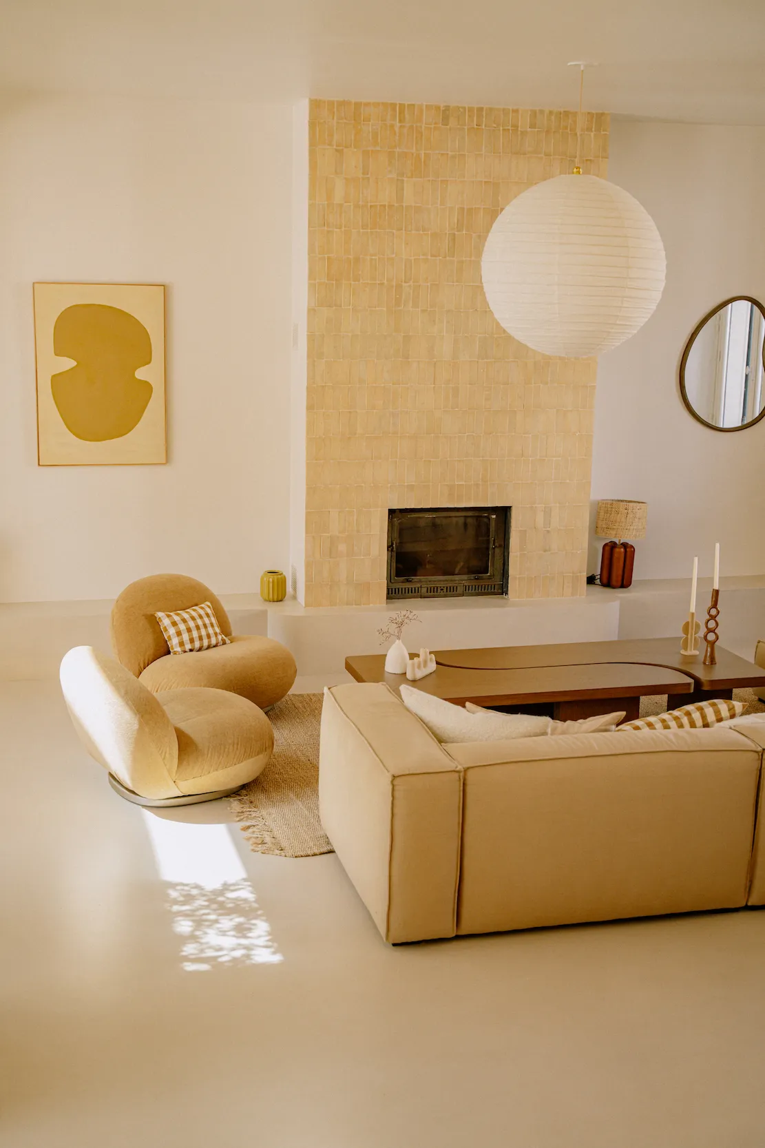 A warm, creamy microcement floor softened by a wool rug in a Nantes home