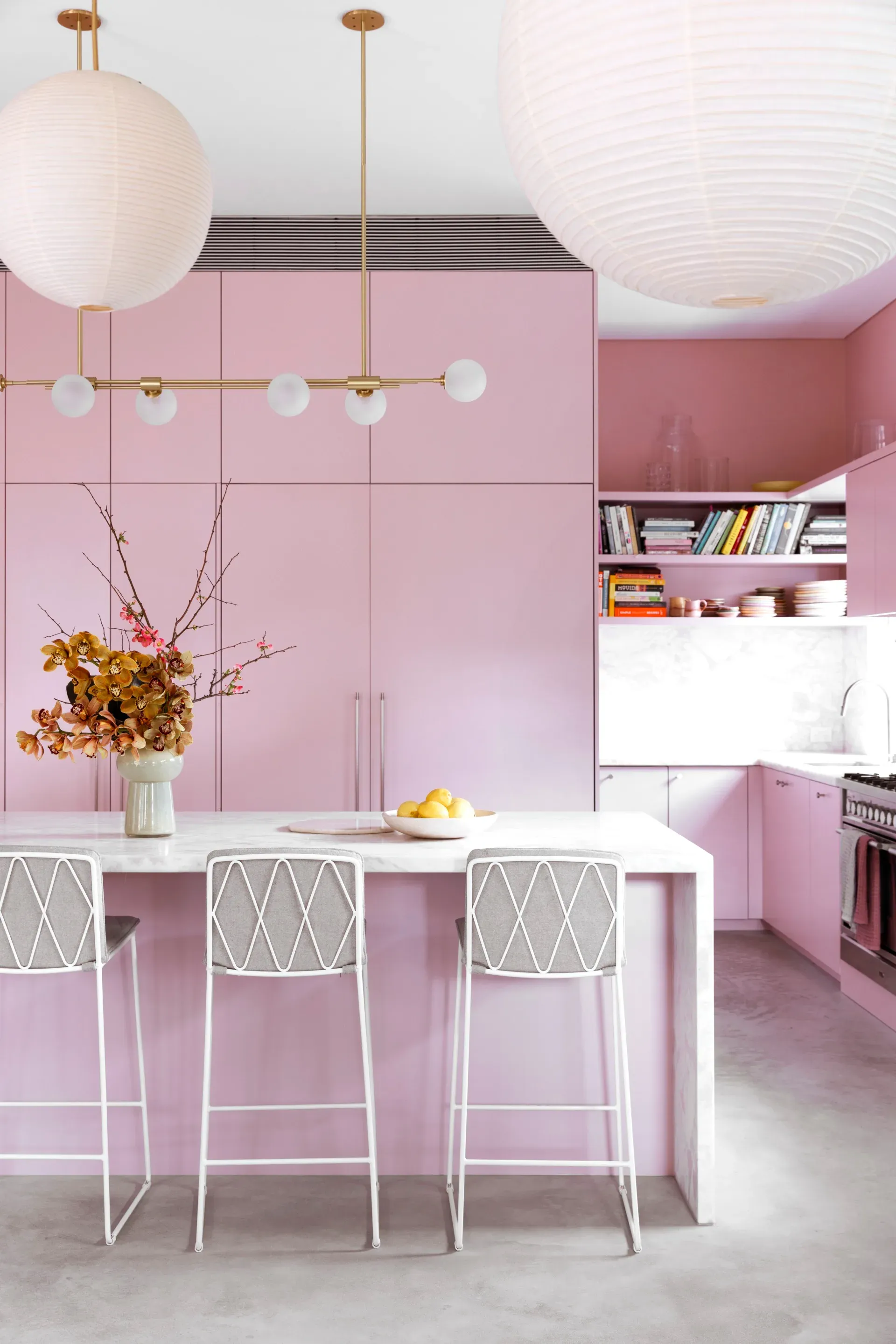 A bold pink kitchen on a grey polished-concrete floor