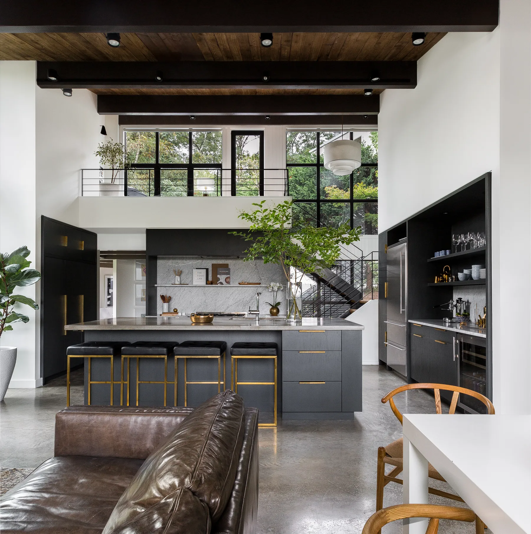A polished concrete floor under black cabinetry and a timber ceiling