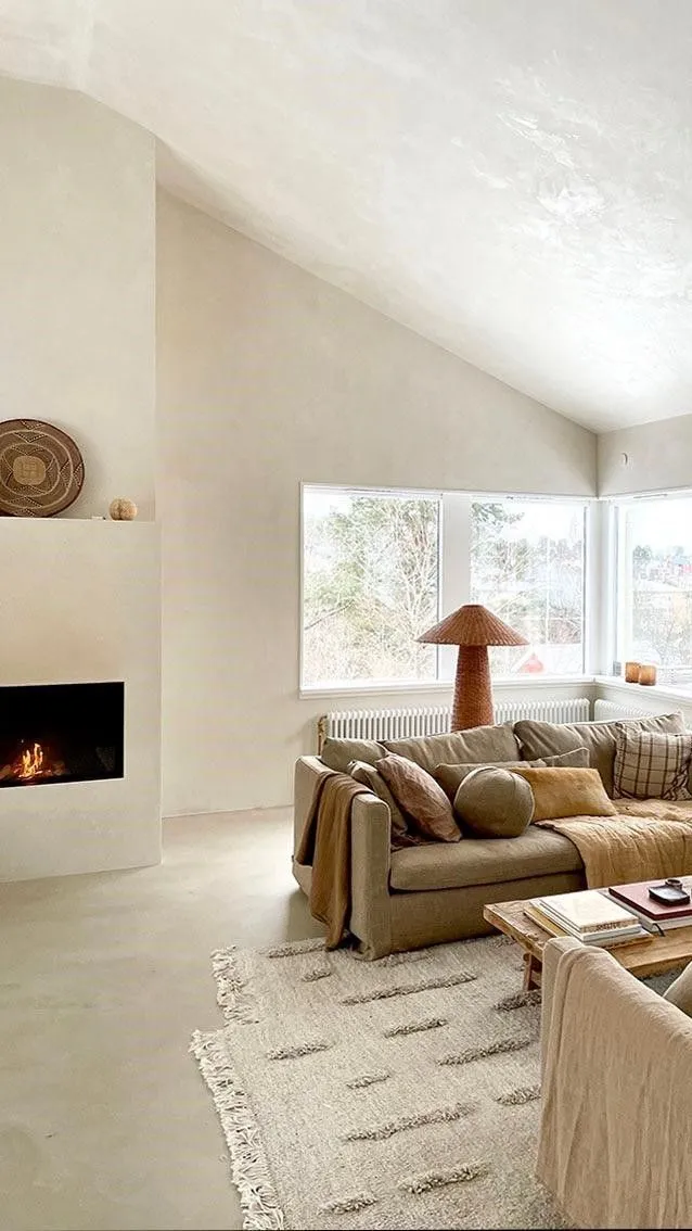 A plaster fireplace the colour of unbleached calico, the finish rolled straight up the chimney breast and into the vault.